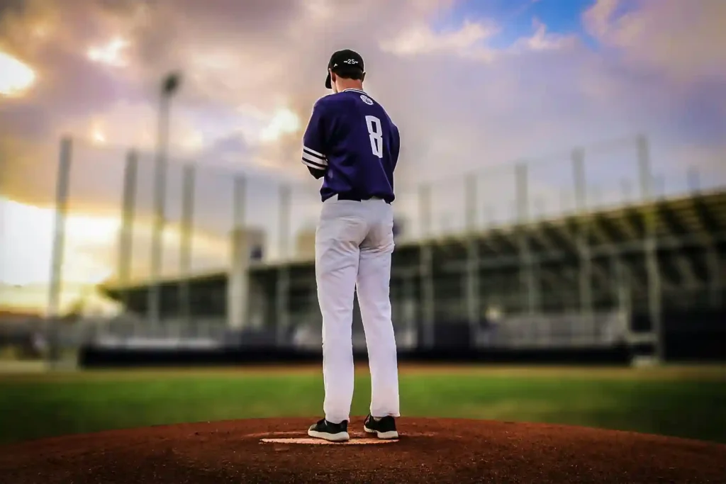 A baseball player on a mound at sunset, wondering how much bat boys make