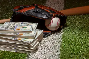 How Much Do Ball Boys and Girls Make in the MLB? 2 A baseball glove rests on artificial turf beside a stack of cash and a baseball, symbolizing sports and finance, referencing the topic of how much MLB ball boys girls make.