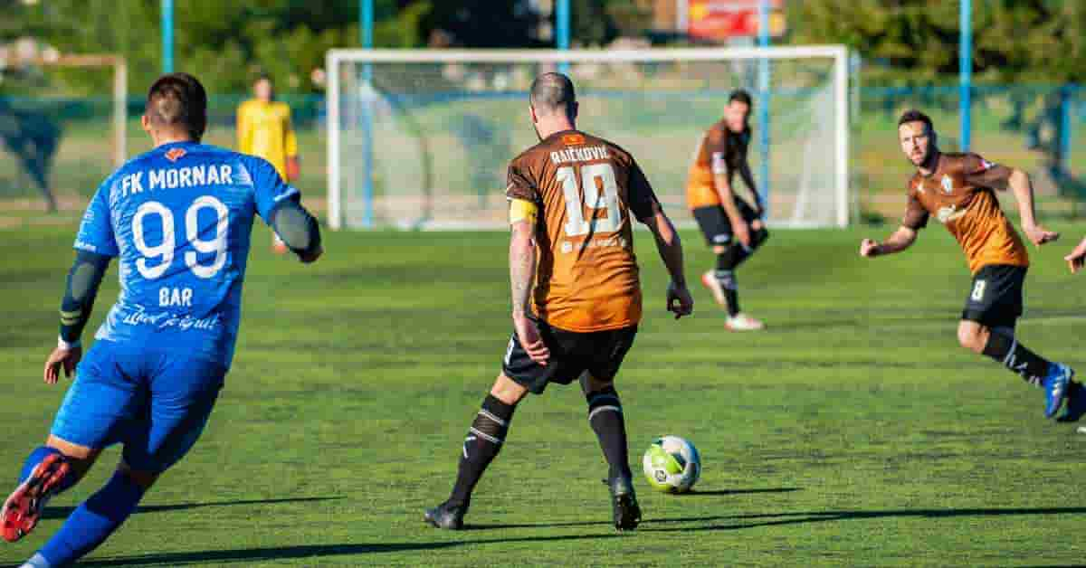 Soccer players setting up for a penalty shot in a competitive match.