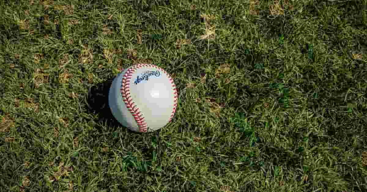 A baseball, related to the position of shortstop in baseball, lies on a grassy field.