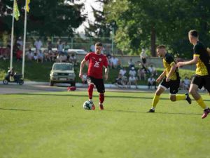 Three soccer players in action on a grass field, two in yellow and one in red, demonstrating strategies that could be related to point shaving in football.