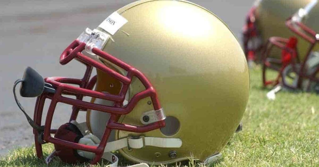 A row of football helmet stickers sitting on top of a field.