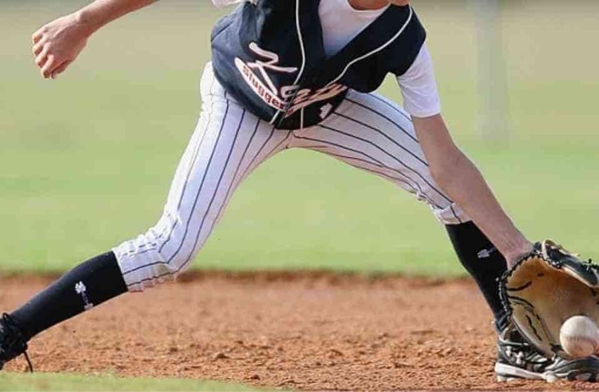 A baseball player wearing a catcher's mitt on a field as an umpire oversees the game, highlighting the importance of roles and salaries like those of MLB umpires.