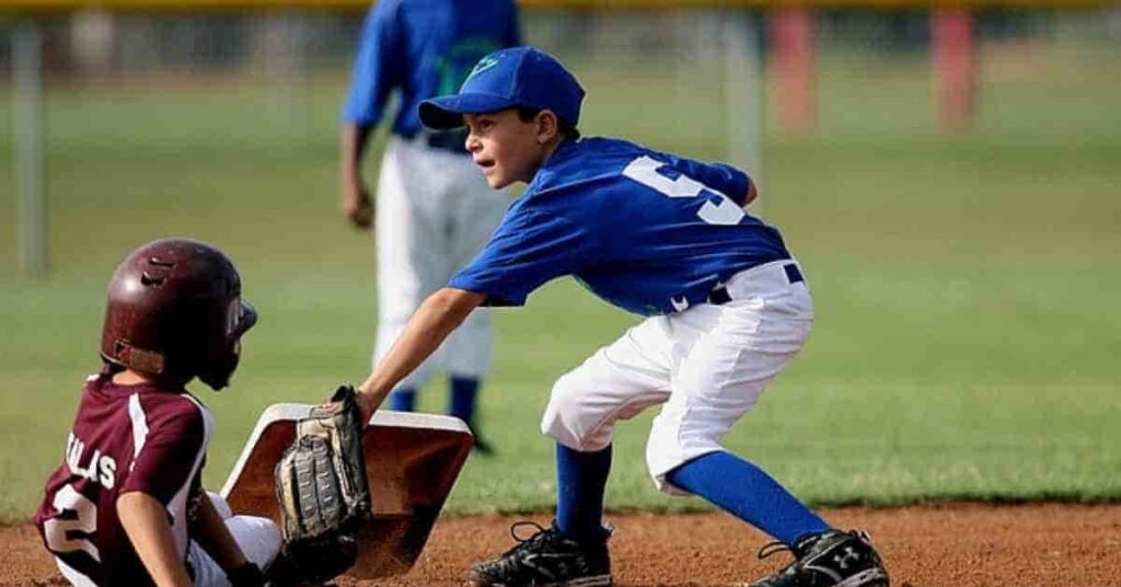 A young baseball player sliding into home plate, symbolizing the discussion on how do MLB players get paid.