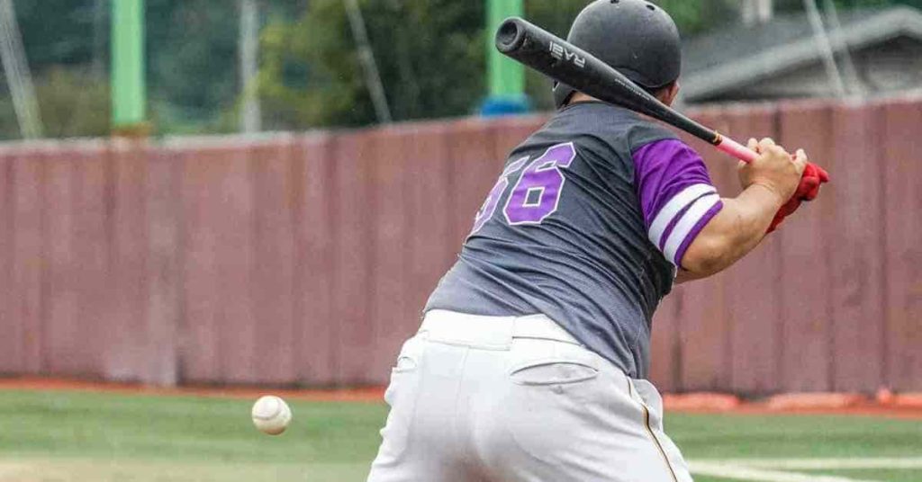 A baseball player swinging a bat at a ball, inspired by his Baseball Walk-Up Song.