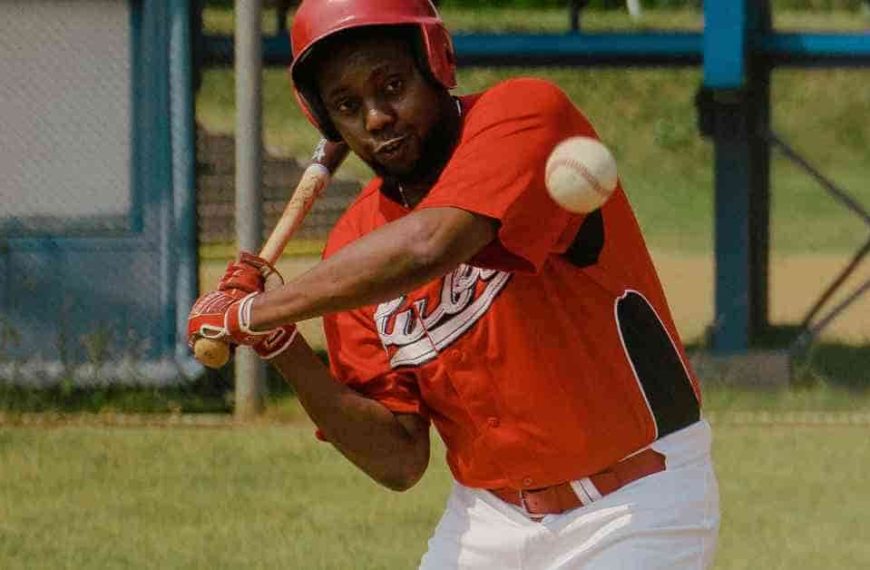 A baseball player swinging a bat at a ball, with his baseball walk up songs playing in the background.