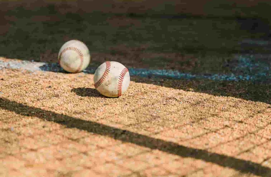 Two baseballs are sitting on a baseball field, representing the journey to discover how much do minor league baseball players make.