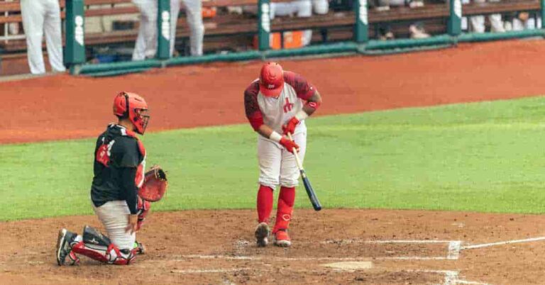 Orelvis Martinez, a baseball player, holding a bat on top of a field, symbolizing his potential as a future star.