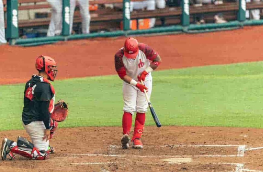 Orelvis Martinez, a baseball player, holding a bat on top of a field, symbolizing his potential as a future star.