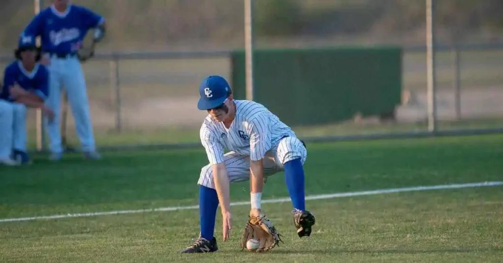 a baseball player bending down to catch a ball, highlighting the skills of the oldest players