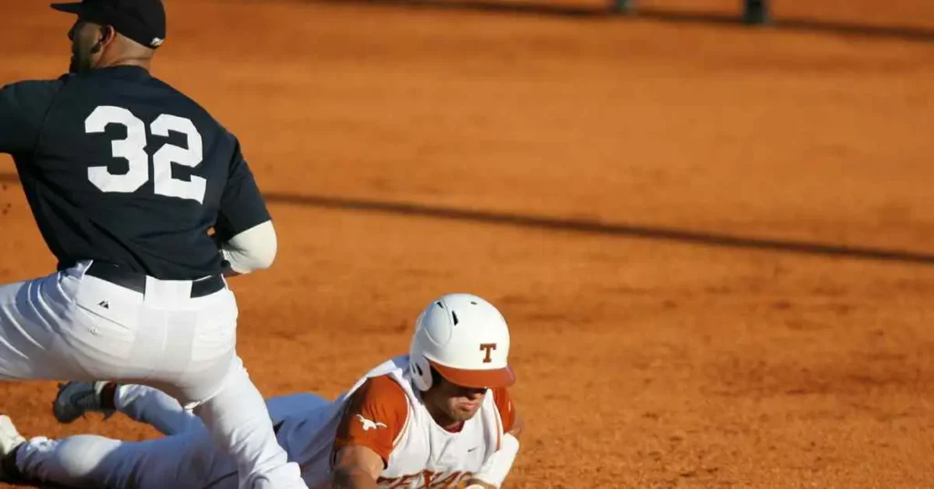 How Many Acres For a Baseball Field- An Ultimate Guide To Baseball 4 A baseball player sliding into a base during a game on a baseball field.