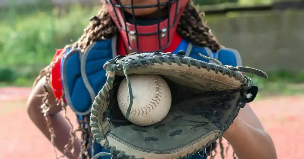 a catcher's mitt with a baseball inside of it, used by one of the oldest players on the field