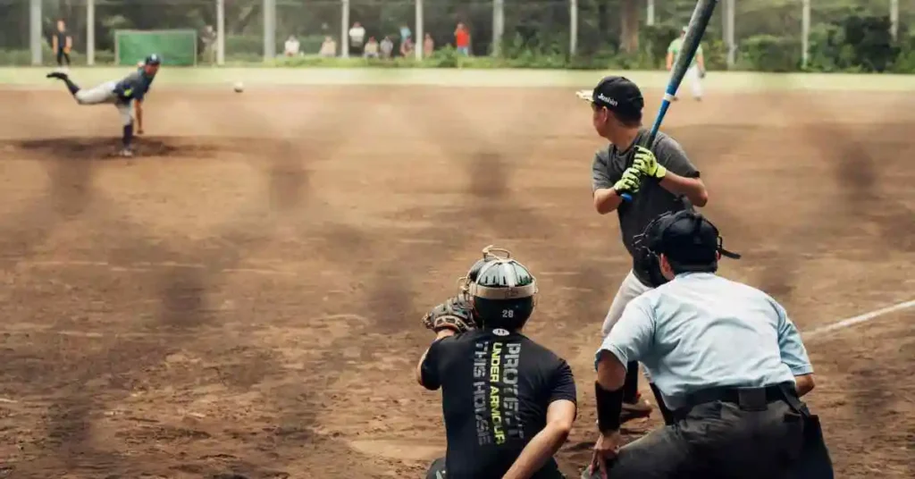 Baseball Positions by Number.. The Complete Guide 3 A youth baseball game in progress, illustrating Baseball Positions by Number, with a player pitching, a batter ready to swing, and an umpire behind the catcher.