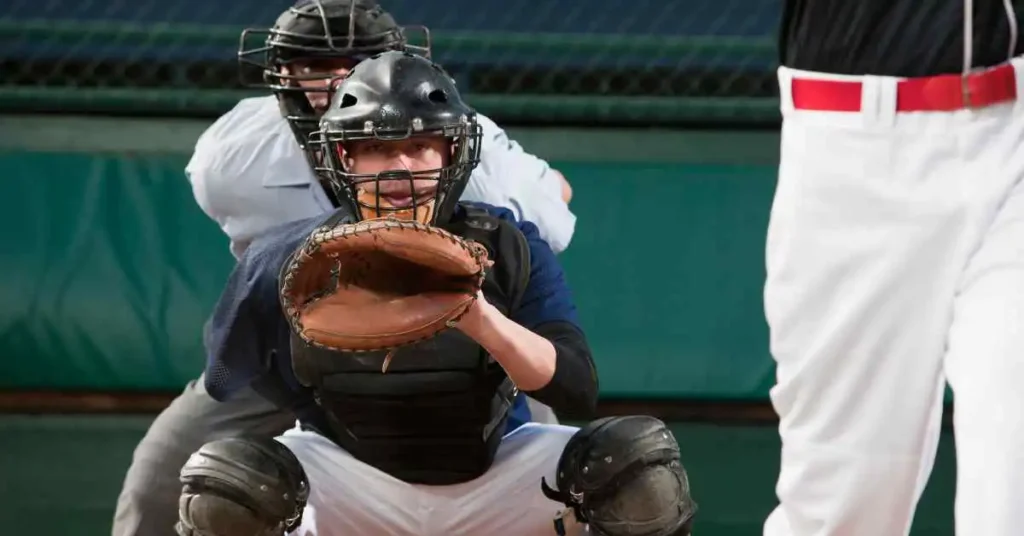 How Many Acres For a Baseball Field- An Ultimate Guide To Baseball 3 A baseball player kneeling down holding a catcher's mitt on a baseball field.