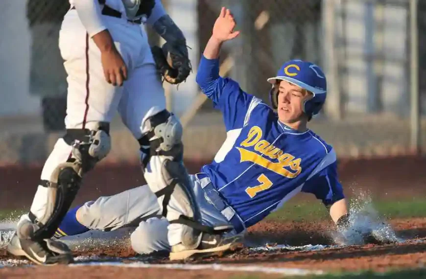 A baseball player sliding into home plate during a game, showcasing a key baseball term in action.